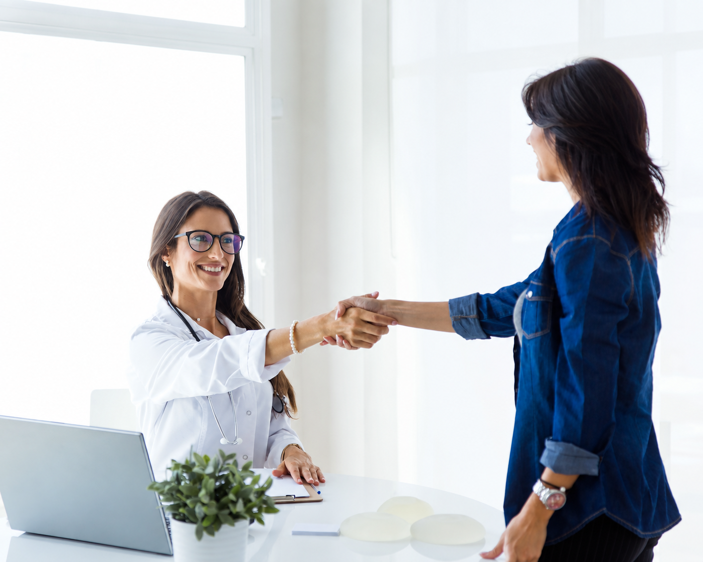 Audiologist and patient shaking hands during a consultation